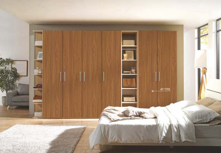 Brown wood grain laminate texture on closet doors and shelves in a modern bedroom with white bedding and decor.