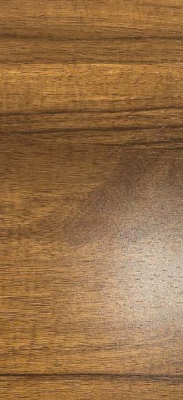 Brown wood grain laminate with textured finish and visible wood pattern and sheen variation in a decorative laminate sheet