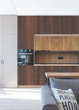 Dark wood laminate wall with glossy finish and wood grain texture in modern kitchen interior design setting