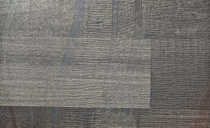 Dark wenge wood laminate with textured finish and wood grain pattern, showing varied texture and tone in a close-up view.