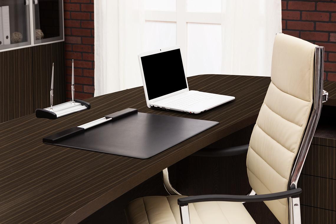 Brown wood grain laminate desk with striped pattern and suede finish in a modern office setting with laptop and chair