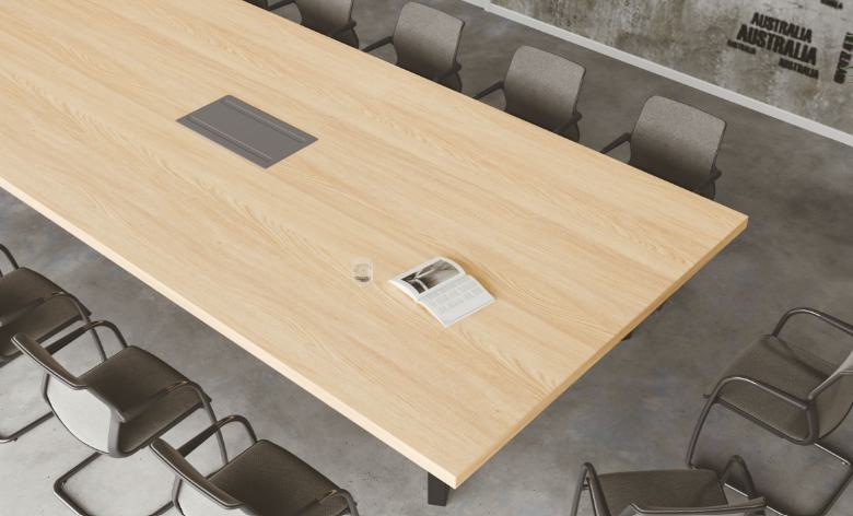 Light brown wood laminate table top with wood grain texture and smooth finish in a modern conference room setting