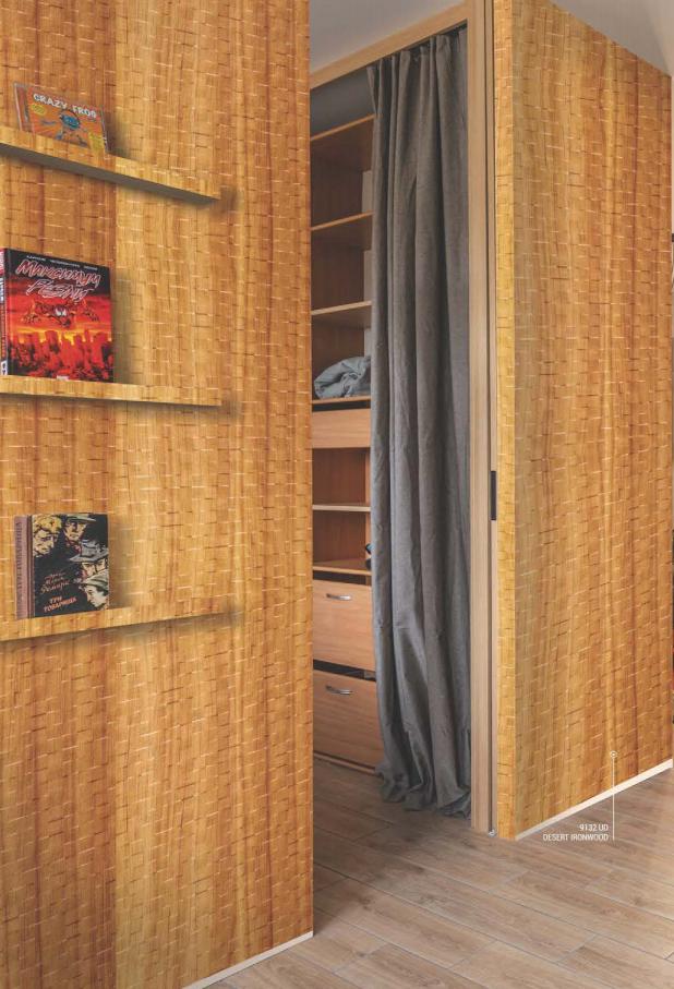 Brown wood laminate wall with textured finish and built-in shelving unit, showcasing storage space with books and folded