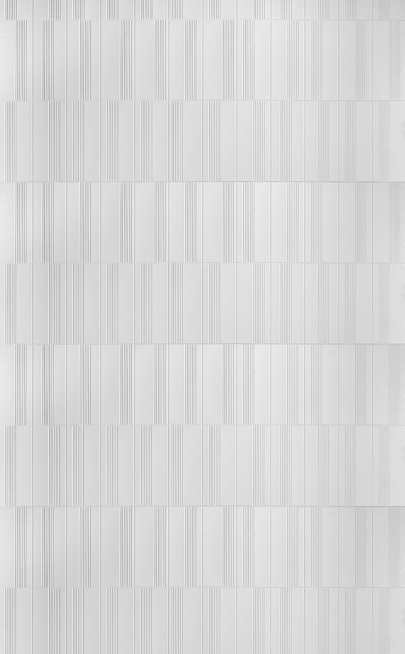 White fluted wall panel with textured finish and vertical grooves, showing a repeating pattern of rectangular sections.