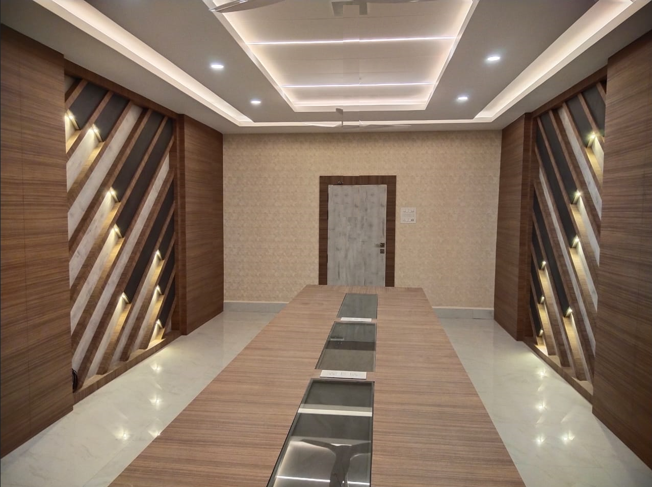 Brown wood laminate decorates conference room walls and table, with diagonal slats and marble floor accents visible in
