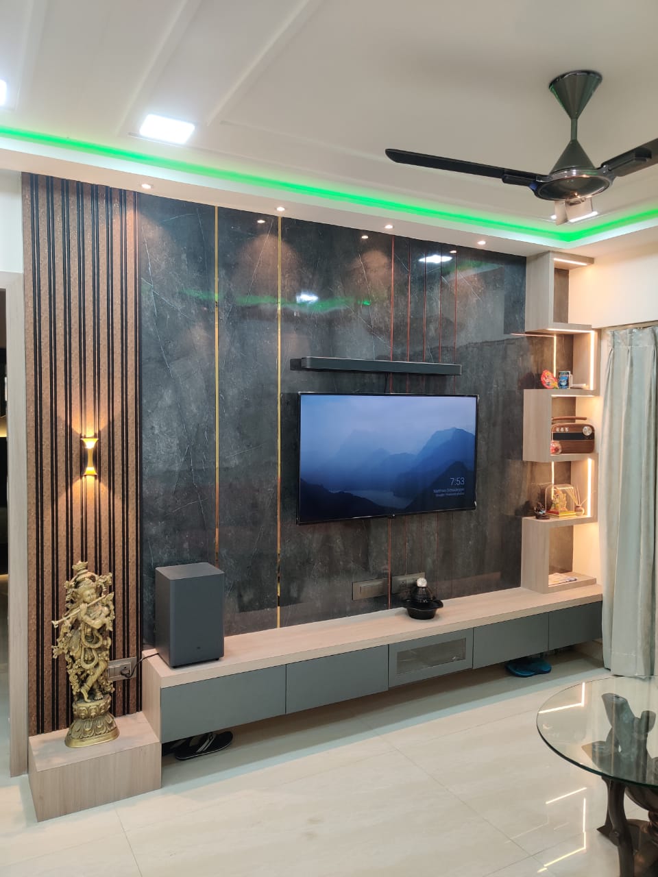 Dark grey marble laminate wall with gold accents and vertical stripes, used in modern living room with TV and decorative