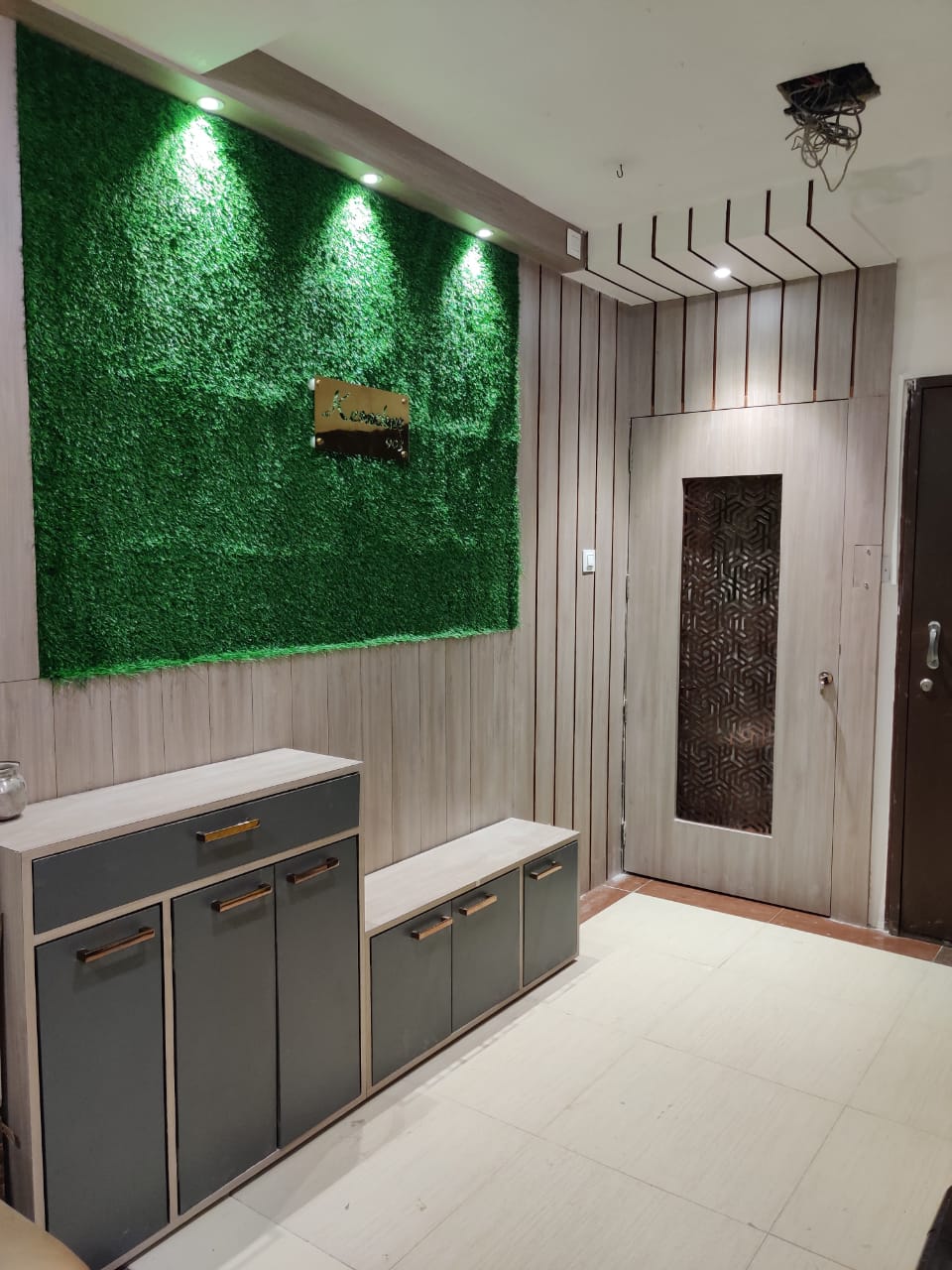 Light wood laminate wall with vertical grain, used in modern interior with green accent wall and minimalist furniture.