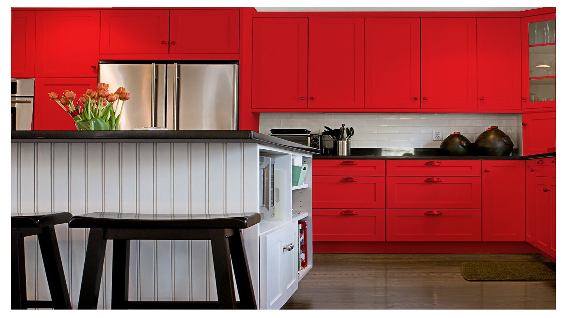Red matte laminate kitchen cabinets with raised panel design and black countertops in a modern kitchen setting.