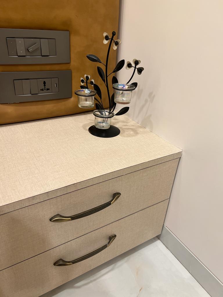 Multi-colour fabric laminate with matte finish on dresser and wall panel, showing textured surface and subtle sheen.