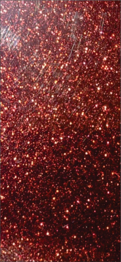 Red metallic laminate with textured finish and sparkling dots, showing reflective sheen and subtle scratches.