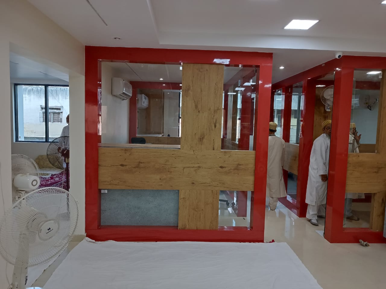 Wooden laminate partition with matte finish in modern interior setting with red frames and glass sections, creating a sleek