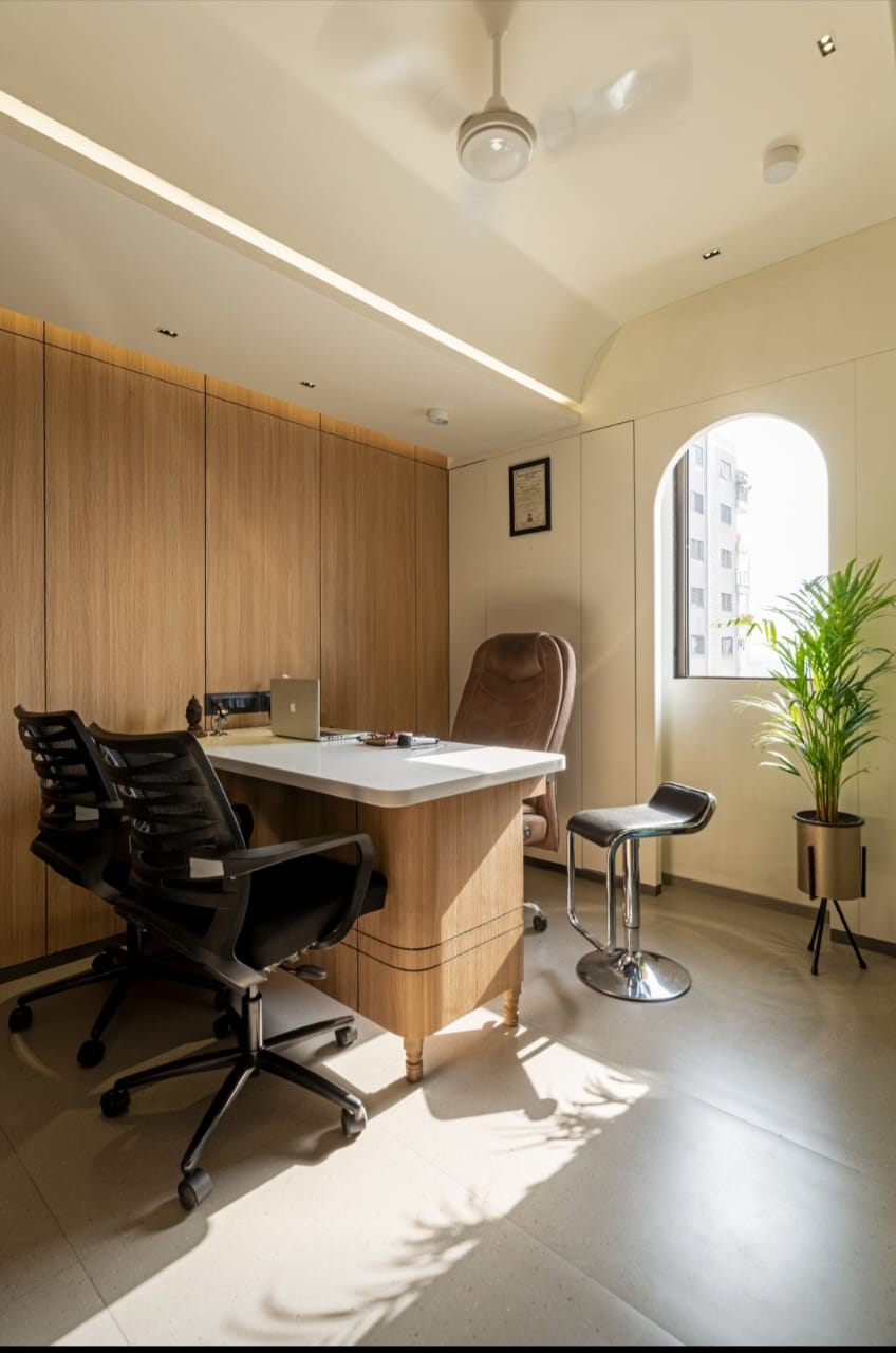 Wood laminate wall and desk in modern office with natural light, wood grain texture visible on laminate surface.