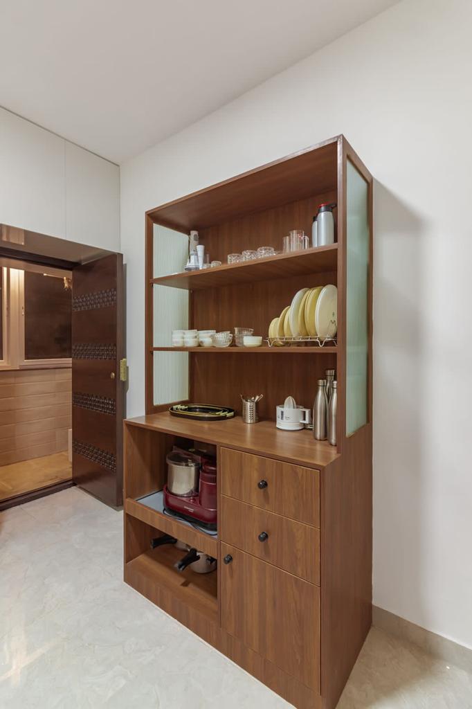 Brown wood laminate cabinet with matte finish, visible wood grain, and various household items on shelves and in drawers.
