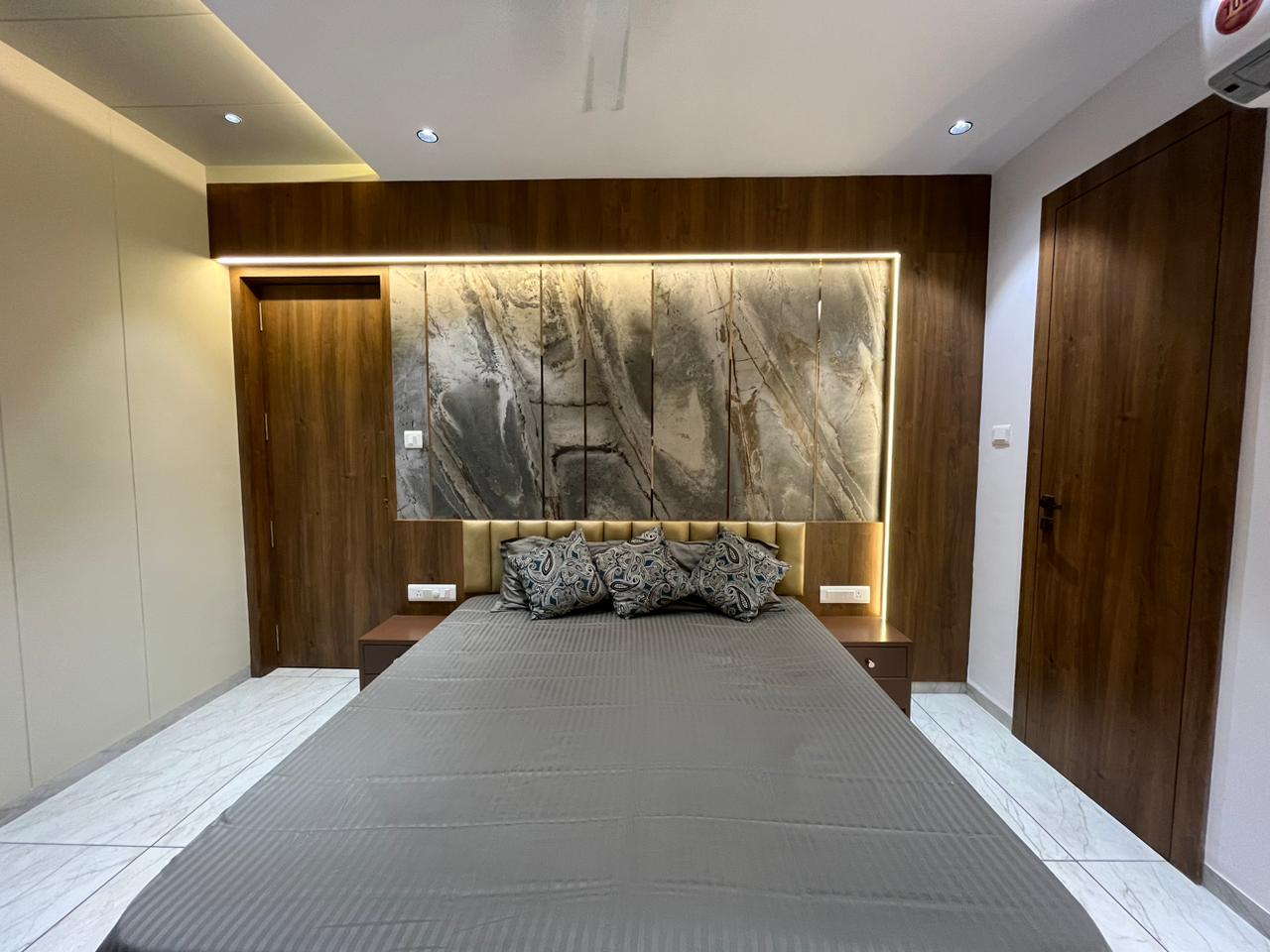 Multi-colour marble patterned laminate wall with matte finish in a modern bedroom setting with wooden accents and LED