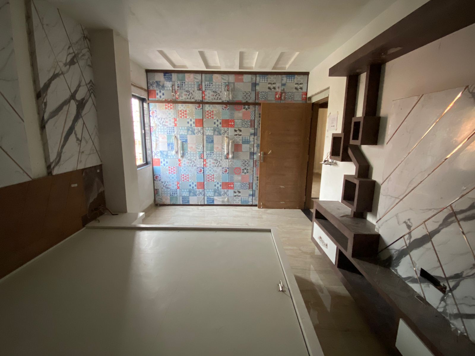 Grey patterned laminate in a room with marble walls and furniture, showing matte finish and geometric design on cabinet