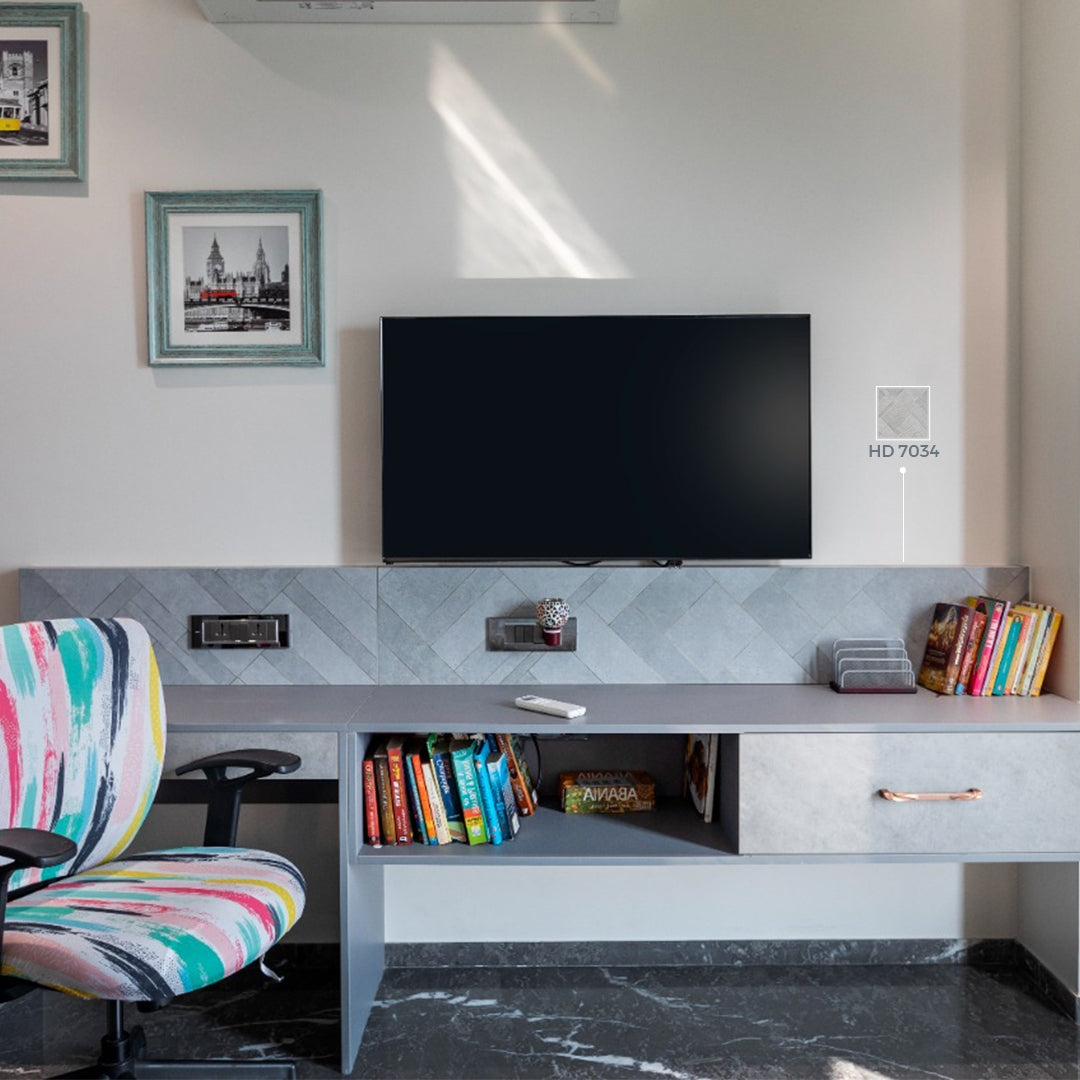 Grey marble laminate with matte finish and herringbone pattern on wall behind TV in modern home office setup
