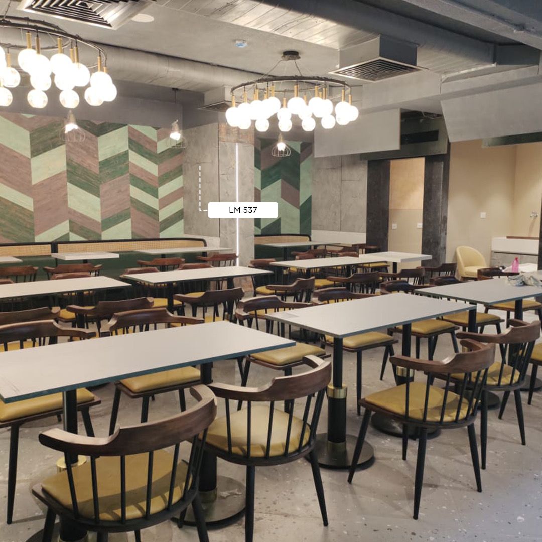 Multicolored chevron patterned laminate LM 537 on wall in modern restaurant setting with tables and chairs
