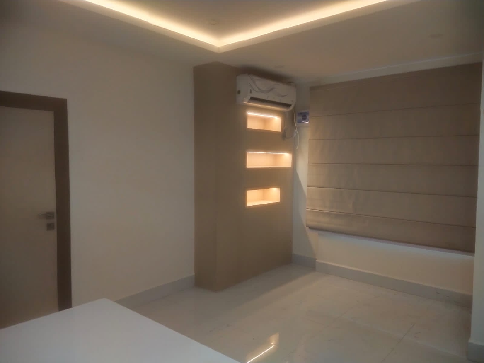 Beige leather laminate wall with matte finish and horizontal pattern in a modern interior setting with recessed lighting