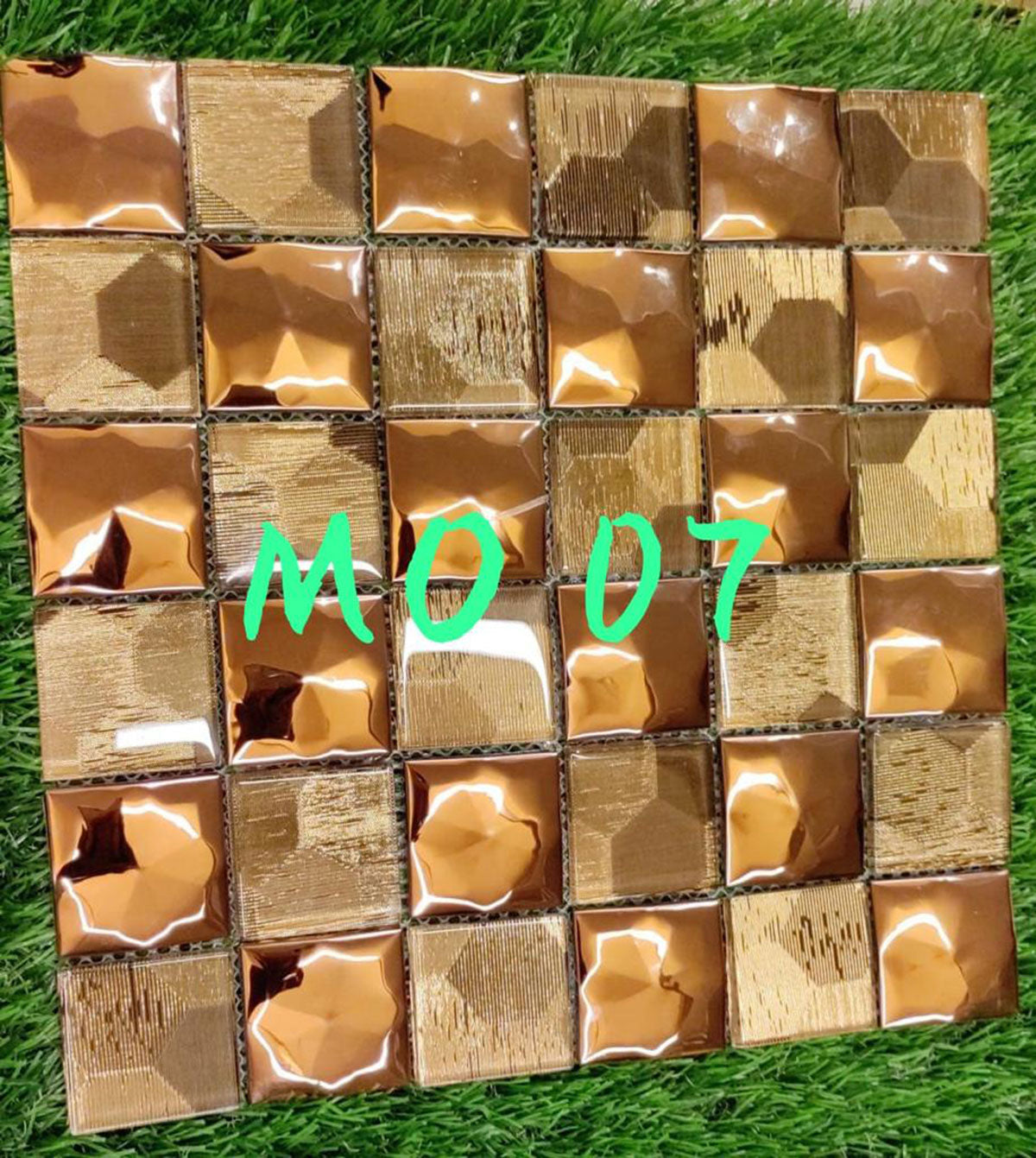 Gold metallic louver panel with textured finish and varied sheen on individual tiles in a grid pattern.