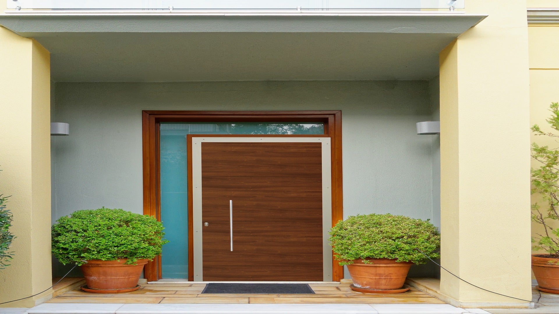 Wood laminate door with matte finish and wood grain texture used in modern entrance with potted plants and minimalist decor