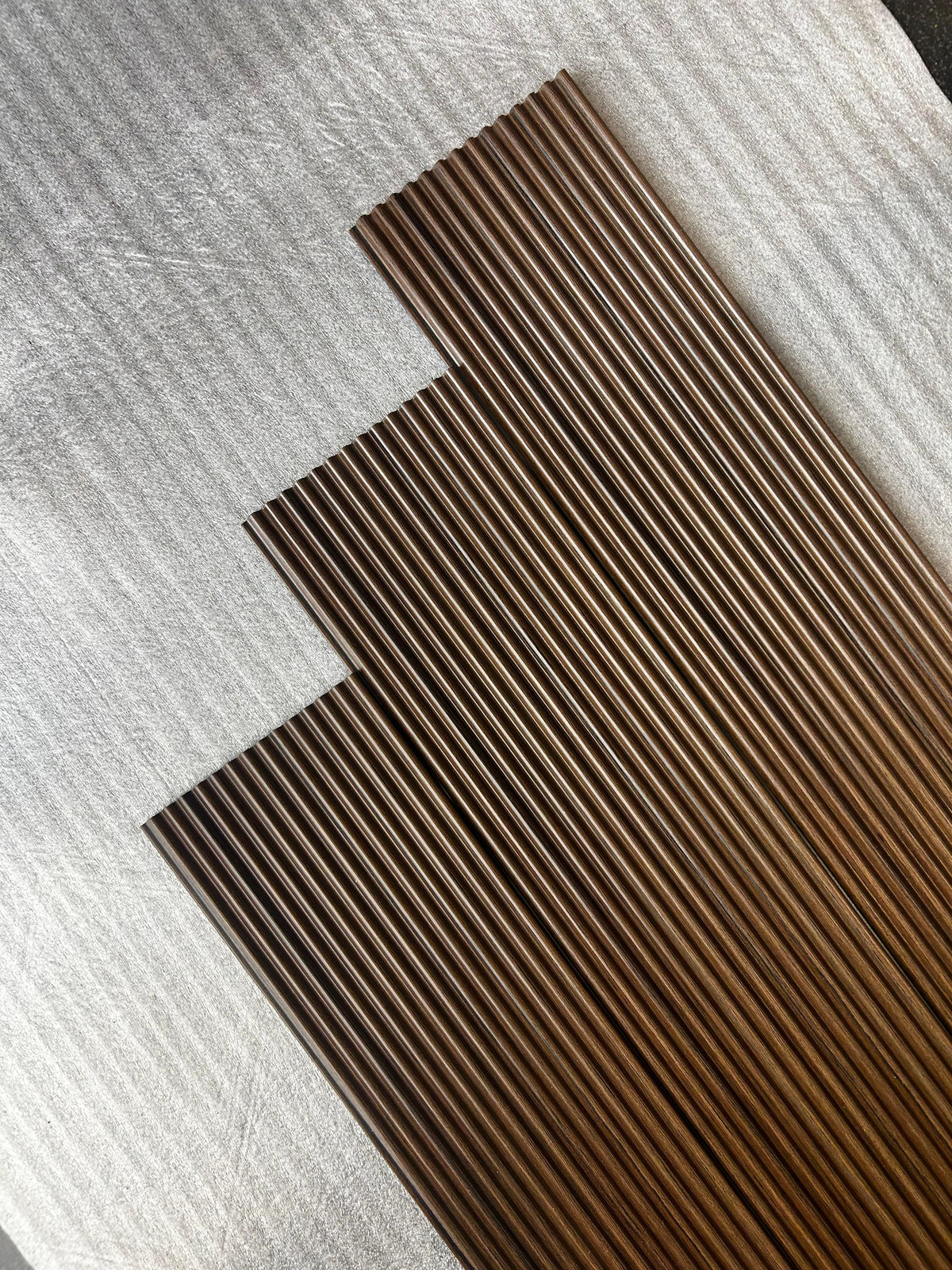 Angled view of fluted louvers in dark walnut brown wood grain, code 9593