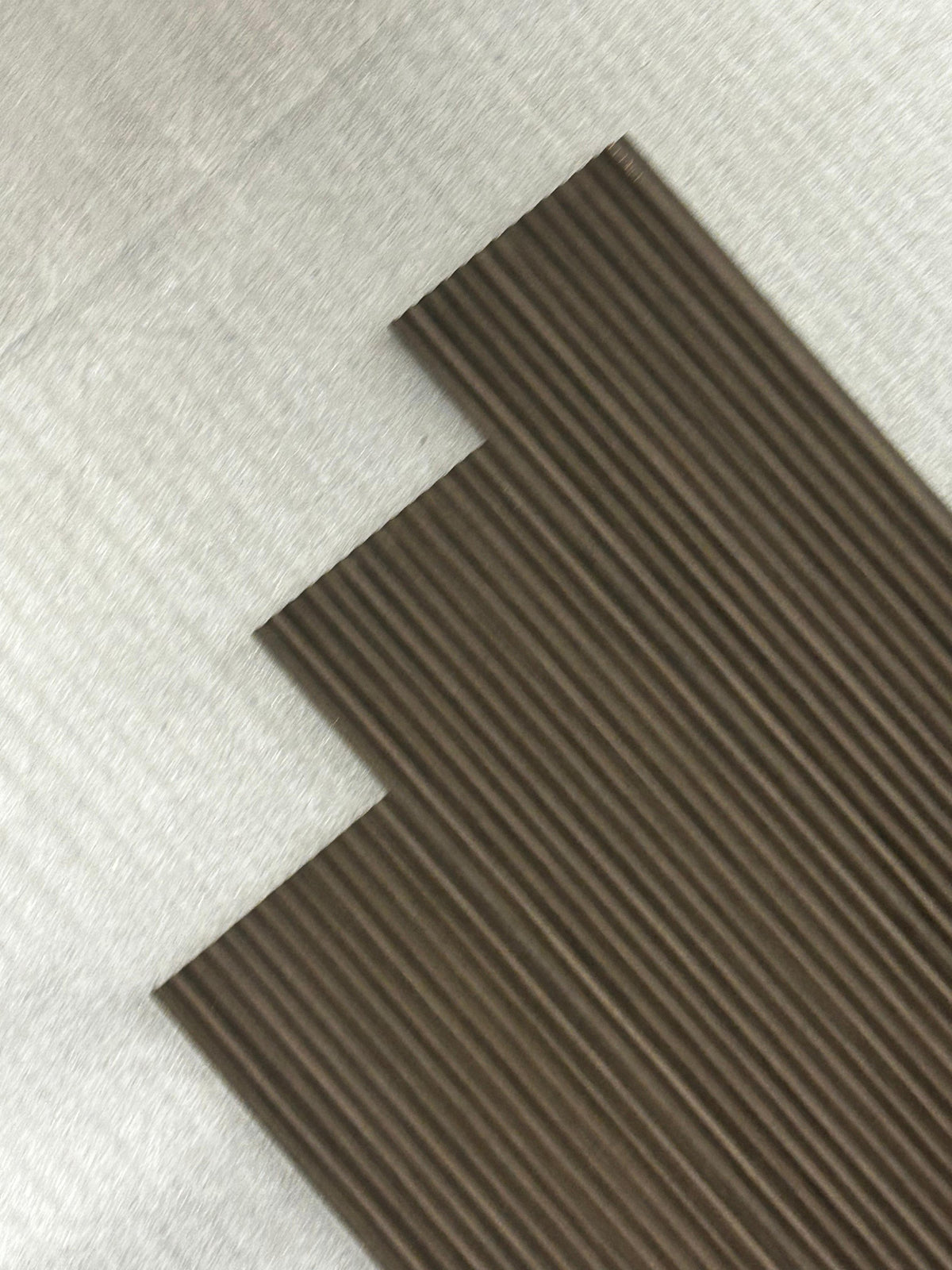 Angled view of fluted louvers in dark taupe brown wood grain, code 9597