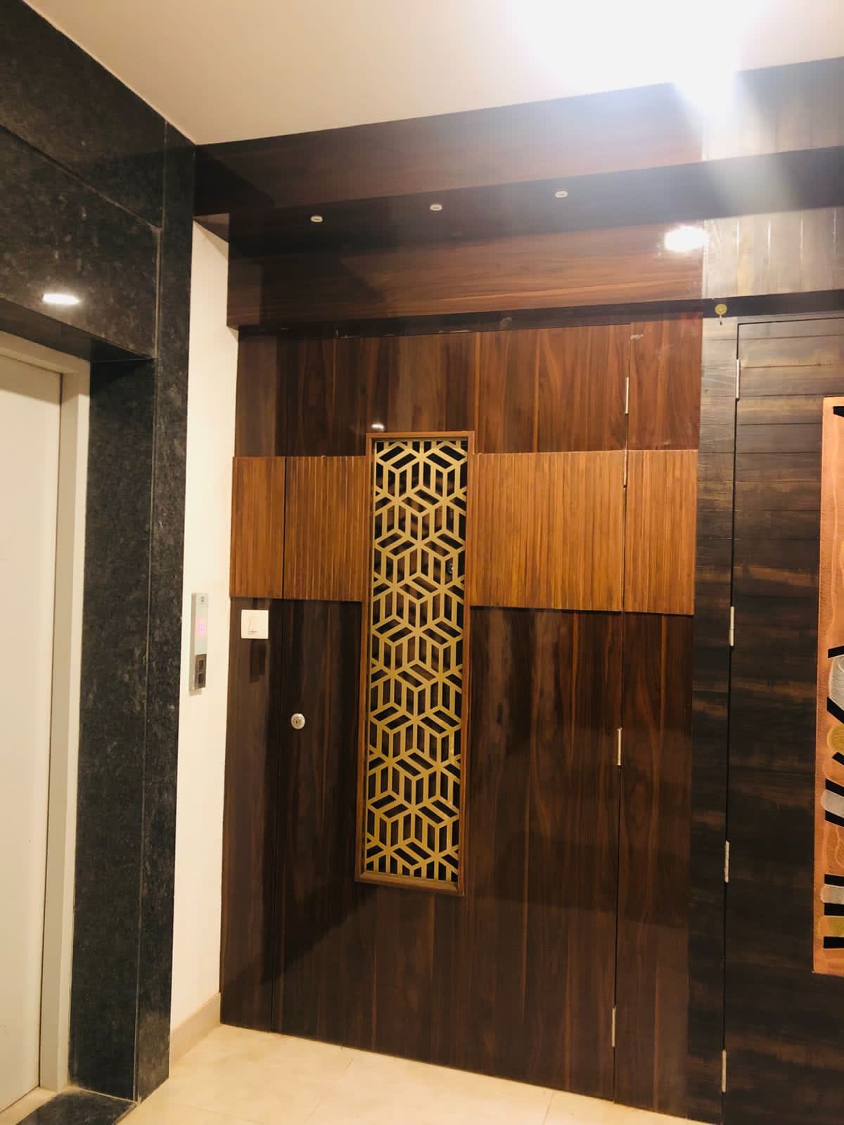 High gloss wood laminate wall with dark brown and beige panels and geometric pattern in modern interior design setting
