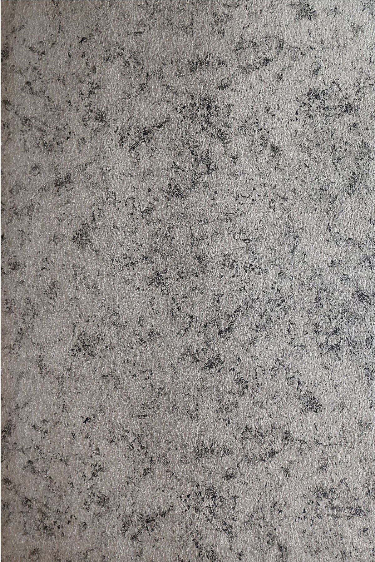 Grey marble laminate with textured finish and black speckles, showing stone pattern and rough surface detail.