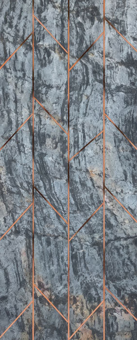 Grey marble wall panel with textured finish and copper accents in geometric pattern