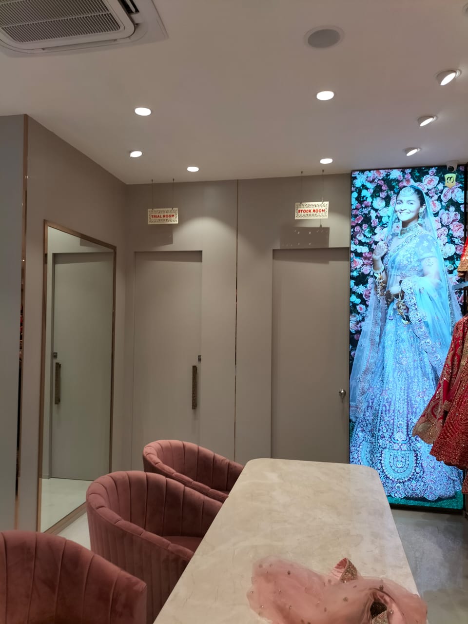 Brown matte laminate wall with smooth finish in a dressing room setting with pink chairs and a marble table