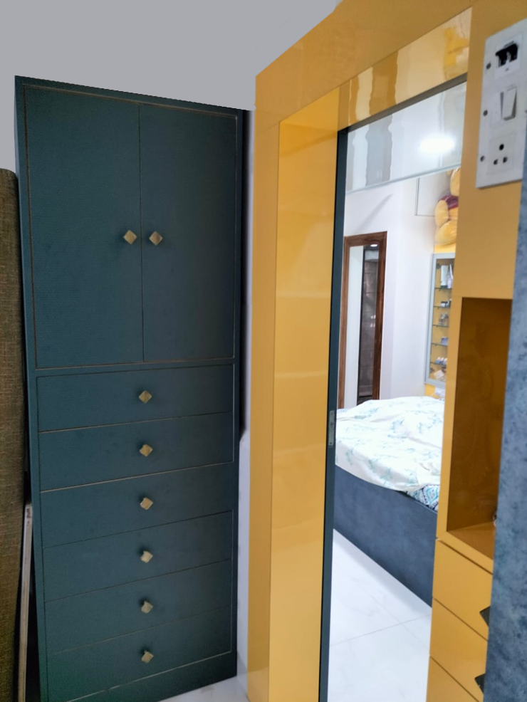 Yellow glossy laminate wardrobe and dark green cupboard in a bedroom with white floor and bedding.