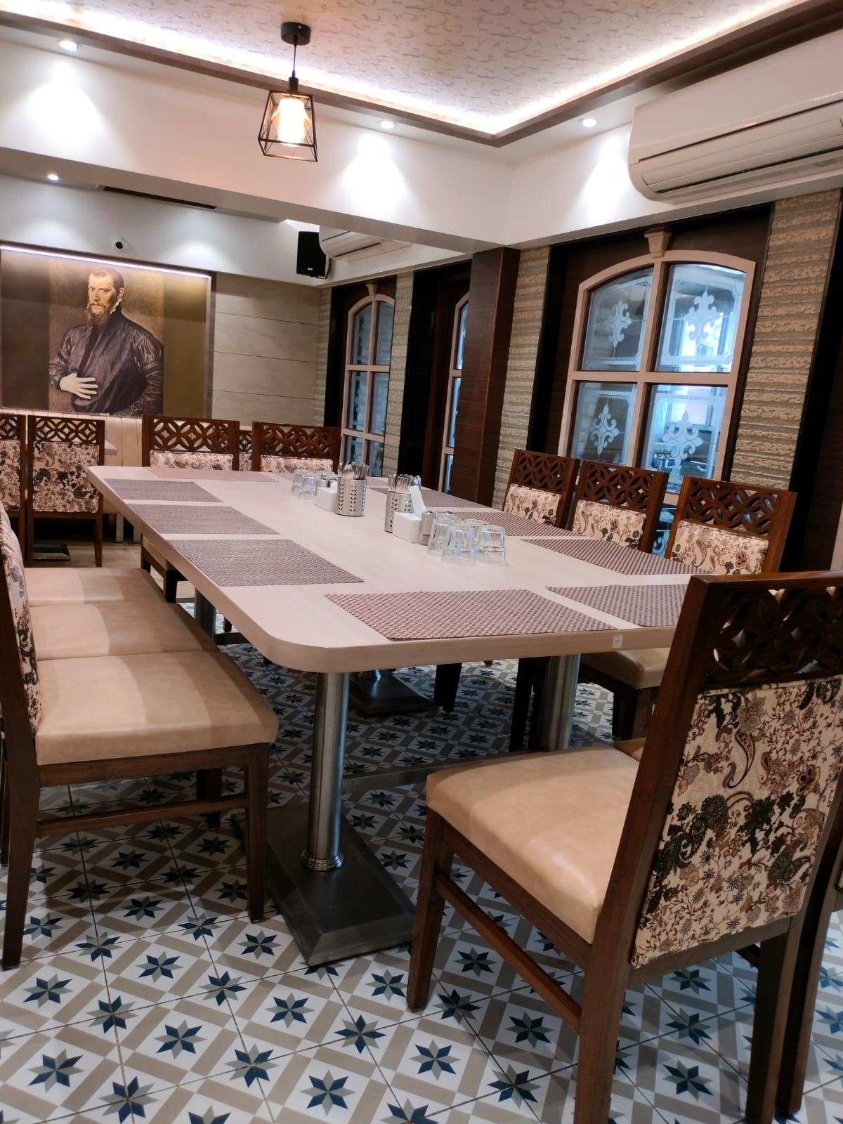 Brown wood laminate used on dining room walls and pillars with patterned tiles and floral upholstered chairs