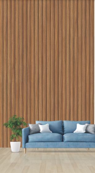 Brown wood grain PVC louver panel on wall behind blue sofa with pillows and potted plant in modern interior setting